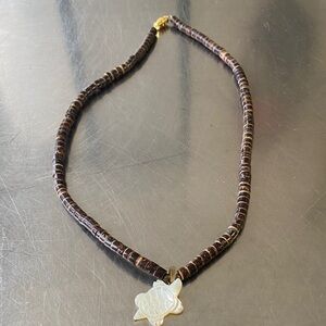 surfer-style coconut bead necklace featuring a white turtle pendant